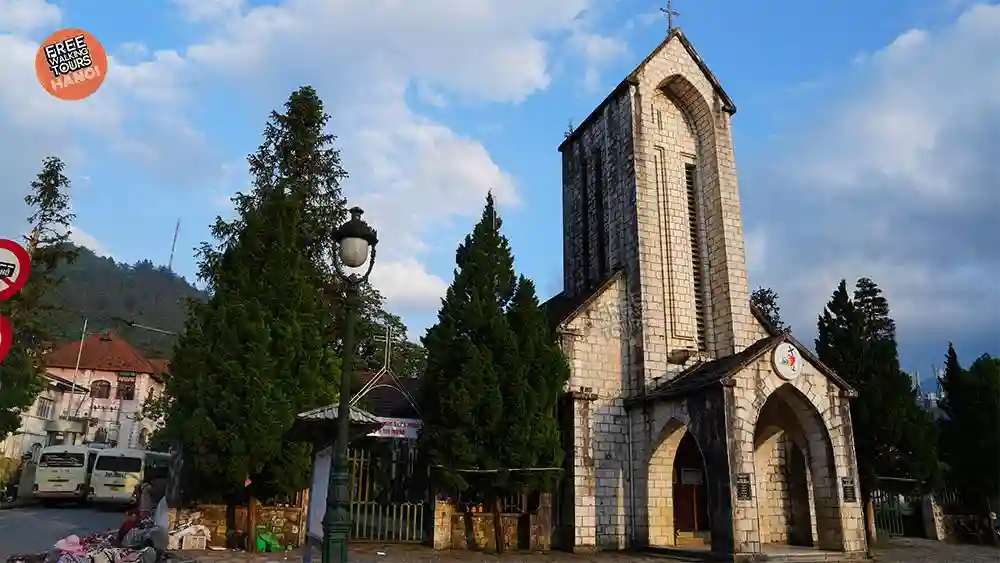 Sapa Stone Church, a French colonial-era stone landmark in the centre of Sapa Town, framed by pine trees under a blue sky